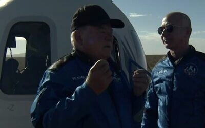 William Shatner (left), with Jeff Bezos, at the end of his space voyage, October 13, 2021 (CBS screenshot)