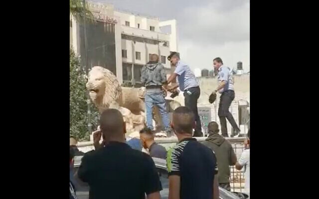 Palestinian Authority police detain a man using a hammer to smash the iconic lion statues in the West Bank city of Ramallah's al-Manara Square, October 17, 2021. (Screen capture: Twitter) Palestinian Authority police detain a man using a hammer to smash the iconic lion statues in the West Bank city of Ramallah's al-Manara Square, October 17, 2021. (Screen capture: Twitter)