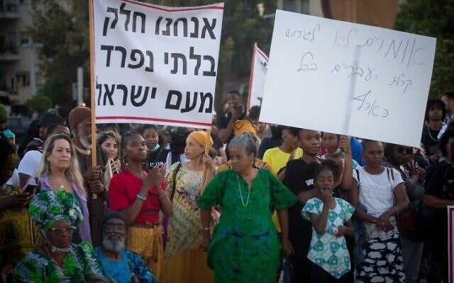 Members of the Hebrew Israelites Community of the southern city of Dimona protest against deportation orders given to some of their members, Habima Square, Tel Aviv, June 1, 2021. Th banner says, 'We are an integral part of the People of Israel.' (Miriam Alster/Flash90) Members of the Hebrew Israelites Community of the southern city of Dimona protest against deportation orders given to some of their members, Habima Square, Tel Aviv, June 1, 2021. Th banner says, 'We are an integral part of the People of Israel.' (Miriam Alster/Flash90)