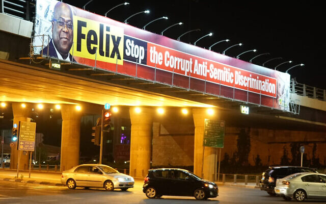 Cars travel under a bridge criticizing Congolese President Felix Tshisekedi in Jerusalem on October 26, 2021. (Courtesy of organizers via JTA) Cars travel under a bridge criticizing Congolese President Felix Tshisekedi in Jerusalem on October 26, 2021. (Courtesy of organizers via JTA)