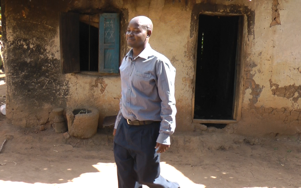 Dr. Samson Wamani in front of his childhood home in the village of Nasenyi in 2014. (Bernard Dichek)
