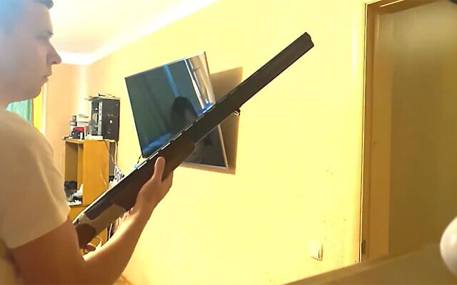 Andrei Zeltzer stands with a hunting rifle behind the door of his home in Minsk, Belarus on Sept. 29, 2021. (Maria Uspenskaya) Andrei Zeltzer stands with a hunting rifle behind the door of his home in Minsk, Belarus on Sept. 29, 2021. (Maria Uspenskaya)