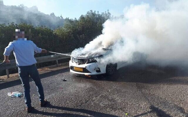 'Resh,' the man slated to take over as the head of the Shin Bet security service, helps a motorist put out a fire while on his way to a meeting vetting him for the post, October 8, 2021 (Channel 12 screenshot) 'Resh,' the man slated to take over as the head of the Shin Bet security service, helps a motorist put out a fire while on his way to a meeting vetting him for the post, October 8, 2021 (Channel 12 screenshot)