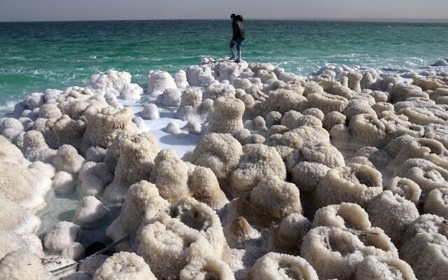 A hiker visits patterns formed by crystalized minerals in Kibbutz Ein Gedi area at the shore of the southern part of the Dead Sea, a dried-up sea stretch which exposed and created a salt plain, seen on December 26, 2020. (Menahem KAHANA / AFP) A hiker visits patterns formed by crystalized minerals in Kibbutz Ein Gedi area at the shore of the southern part of the Dead Sea, a dried-up sea stretch which exposed and created a salt plain, seen on December 26, 2020. (Menahem KAHANA / AFP)