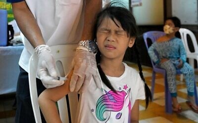 Illustrative -- A girl receives a dose of the Sinovac COVID-19 coronavirus vaccine at a health center in Phnom Penh on November 1, 2021 (TANG CHHIN Sothy / AFP)