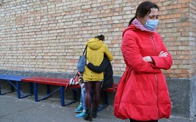 Family members react after they receive information about the death of the relative by COVID-19 coronavirus in Kiev, on November 1, 2021. (Sergei Supinsky/AFP)