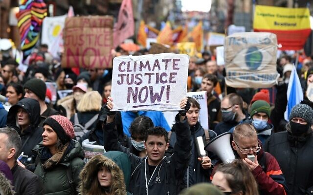 Illustrative: People participate in a protest rally during a global day of action on climate change in Glasgow on November 6, 2021, during the COP26 UN Climate Change Conference. (DANIEL LEAL-OLIVAS / AFP)