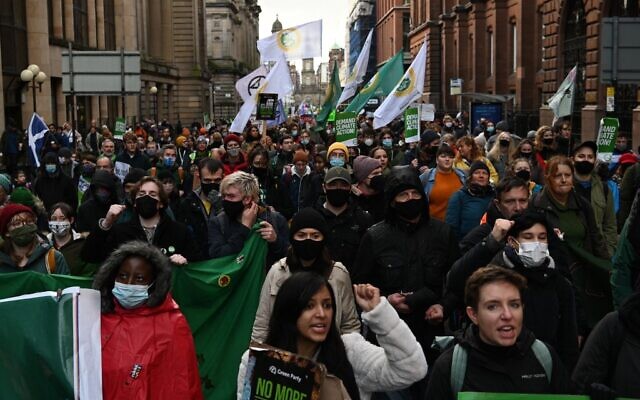 People participate in a protest rally during a global day of action on climate change in Glasgow on November 6, 2021, during the COP26 UN Climate Change Conference. (DANIEL LEAL-OLIVAS / AFP)