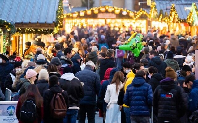 People visit the newly opened "Christkindlmarkt" Christmas market, at the square in front of Vienna's city hall, on November 12, 2021, during the ongoing coronavirus pandemic. (Georg Hochmuth/APA/AFP)