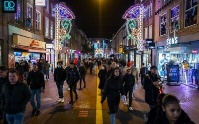 People walk in the streets in Eindhoven, on November 12, 2021 as new COVID-19 restrictions announced (ROB ENGELAAR / ANP / AFP)