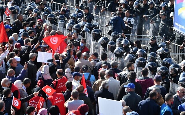 Tunisian demonstrators face security forces as they protest in front of the parliament, against President Kais Saied's seizure of governing powers, in the capital Tunis, on November 14, 2021. (Fethi Belaid/AFP)