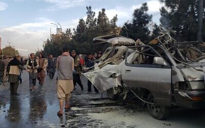 Residents gather next to a damaged minibus after a bomb blast where two people were killed and five wounded in Kabul, on November 17, 2021. (AFP)