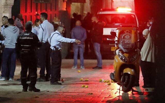 An ambulance drives through as Israeli police gather at the scene of an alleged stabbing attack in Jerusalem's Old City on November 17, 2021. (Ahmad Gharabli/AFP) An ambulance drives through as Israeli police gather at the scene of an alleged stabbing attack in Jerusalem's Old City on November 17, 2021. (Ahmad Gharabli/AFP)