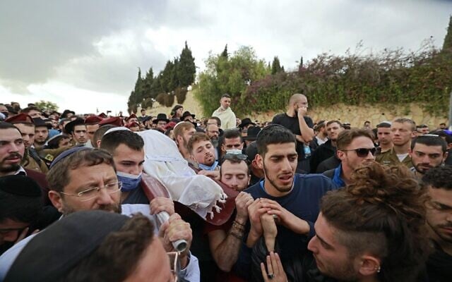 Mourners carry the body of 26-year-old Eliyahu Kay during his funeral in Jerusalem the day after he was killed by a Palestinian gunman in a terror attack, on November 22, 2021. (Menahem KAHANA / AFP)