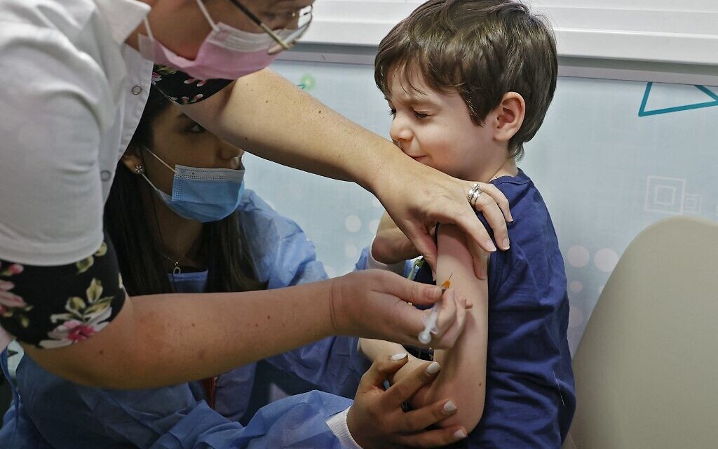 Illustrative: Israeli boy receives a dose of the Pfizer/BioNTech Covid-19 vaccine at the Meuhedet Healthcare Services Organization in Tel Aviv, on November 22, 2021. (Jack Guez/AFP) Illustrative: Israeli boy receives a dose of the Pfizer/BioNTech Covid-19 vaccine at the Meuhedet Healthcare Services Organization in Tel Aviv, on November 22, 2021. (Jack Guez/AFP)