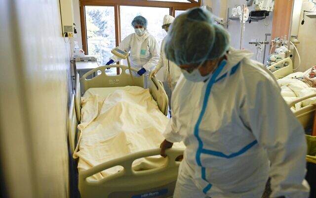 In this file photo taken on November 09, 2021 a medical staff member pushes a trolley bed carrying the body of a deceased Covid-19 coronavirus patient in the intensive care unit of Lozenets Hospital in Sofia, Bulgaria. (Nikolay DOYCHINOV / AFP) In this file photo taken on November 09, 2021 a medical staff member pushes a trolley bed carrying the body of a deceased Covid-19 coronavirus patient in the intensive care unit of Lozenets Hospital in Sofia, Bulgaria. (Nikolay DOYCHINOV / AFP)