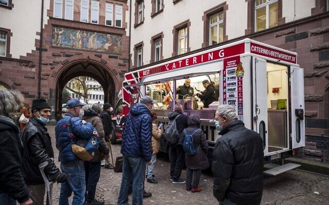 People queue in Frankfurt am Main on November 23, 2021, during an event where people in need are offered the vaccination against the novel coronavirus COVID-19 and a meal. (Thomas Lohnes / AFP) People queue in Frankfurt am Main on November 23, 2021, during an event where people in need are offered the vaccination against the novel coronavirus COVID-19 and a meal. (Thomas Lohnes / AFP)