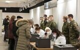 Soldiers of the German Bundeswehr stand behind the counter where the vaccination certificates of freshly vaccinated people are printed as they are briefed for their work in a newly opened vaccination station in Stuttgart, southern Germany, on November 26, 2021, amid the ongoing coronavirus pandemic (THOMAS KIENZLE / AFP)