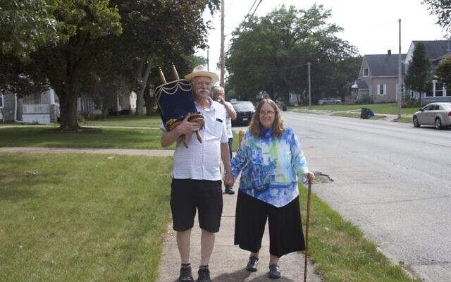 Rabbi Linda Bertenthal (right) and her husband Philip carry their congregation's Torah on its 7.5-mile journey across the Mississippi River, from Rock Island, Illinois, to its new home in Davenport, Iowa. (Beit Shalom Jewish Community/ via JTA)