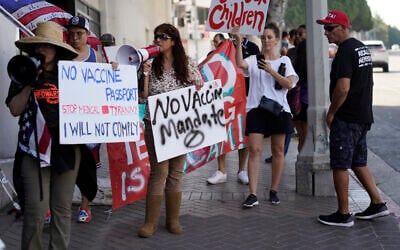 FILE - In this Sept. 9, 2021 photo, anti-vaccine mandate protesters rally outside the garage doors of the Los Angeles Unified School District, LAUSD headquarters in Los Angeles (AP Photo/Damian Dovarganes, File)