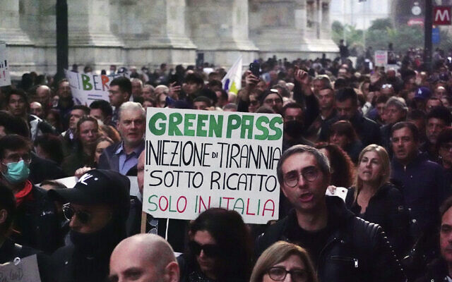 Illustrative: People demonstrate in front of the Duomo gothic cathedral against the 'Green Pass', as one of the most stringent anti-coronavirus measures in Europe went into effect, requiring all workers, from magistrates to maids, to show a health pass to get into their place of employment. in Milan, Italy, Saturday, Oct. 23, 2021. (AP Photo/Luca Bruno) Illustrative: People demonstrate in front of the Duomo gothic cathedral against the 'Green Pass', as one of the most stringent anti-coronavirus measures in Europe went into effect, requiring all workers, from magistrates to maids, to show a health pass to get into their place of employment. in Milan, Italy, Saturday, Oct. 23, 2021. (AP Photo/Luca Bruno)