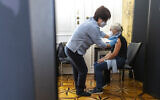 A patient is vaccinated against the COVID-19 virus on the national holiday in the Vienna Imperial Palace in the marble hall in Vienna, Austria, October 26, 2021.  (AP Photo/Lisa Leutner, File)