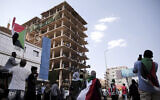 People chant slogans inside a building under construction during a protest in Khartoum, Sudan, Saturday, Oct. 30, 2021. Pro-democracy groups called for mass protest marches across the country Saturday to press demands for re-instating a deposed transitional government and releasing senior political figures from detention. (AP Photo/Marwan Ali)