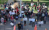 Opponents of COVID-19 vaccine mandates rally outside the Kansas Statehouse, October 30, 2021, in Topeka, Kan. (AP Photo/John Hanna)