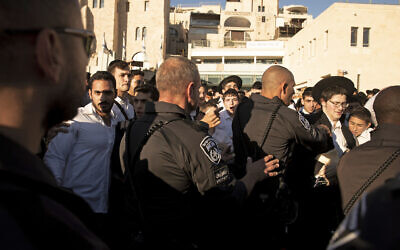 Police scuffle with utra-Orthodox Jews during a protest against the group Women of the Wall holding their Rosh Hodesh, or new month prayer at the Western Wall, the holiest site where Jews can pray, in the Old City of Jerusalem, Friday, Nov. 5, 2021. (AP Photo/Maya Alleruzzo)