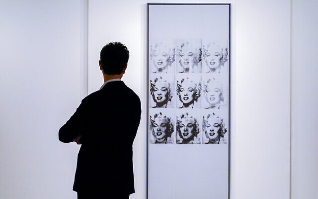 A man inspects Andy Warhol's 'Nine Marilyns' on display at Sotheby's auction house during a press preview for the upcoming The Macklowe Collection auction, Nov. 5, 2021, in New York. (AP Photo/Mary Altaffer)