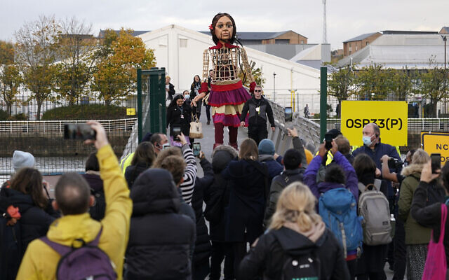 Little Amal, a 3.5m puppet of a 10-year-old Syrian refugee, crosses the Millennium Bridge near the venue of the COP26 UN Climate Summit in Glasgow, Scotland, November 9, 2021. (Alberto Pezzali/AP) Little Amal, a 3.5m puppet of a 10-year-old Syrian refugee, crosses the Millennium Bridge near the venue of the COP26 UN Climate Summit in Glasgow, Scotland, November 9, 2021. (Alberto Pezzali/AP)