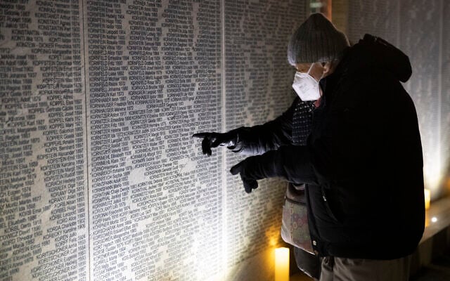 A relative of victims of the NS regime visits the Shoah Wall of Names Memorial after the inauguration ceremony, in Vienna, Austria, Nov. 9, 2021 (AP Photo/Lisa Leutner)