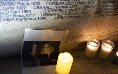A view of the Shoah Wall of Names Memorial lit with a candle and photo left by relatives of victims of the NS regime, after the inauguration ceremony, in Vienna, Austria, Nov. 9, 2021 (AP Photo/Lisa Leutner)