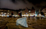 A face mask left on Roemerberg square in Frankfurt, Germany, November 6, 2021. (AP Photo/Michael Probst, file)