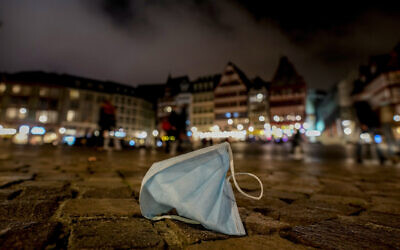 A face mask left on Roemerberg square in Frankfurt, Germany, November 6, 2021. (AP Photo/Michael Probst, file)