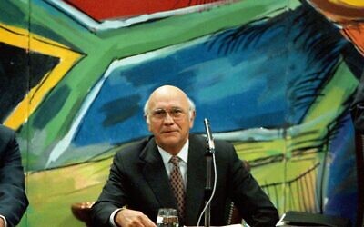 Former president and leader of the National Party F. W. de Klerk, discusses his resignation, below a mural of the new South African flag, at a National Party Caucus meeting in Cape Town, August 26 1997. (AP Photo / Sasa Kralj, file)