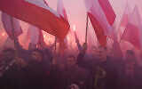 Members of far-right groups light flares as they try to dominate the annual Independence Day march in Warsaw, Poland, on November 11, 2021. (AP Photo/Czarek Sokolowski)