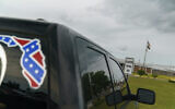 A pickup truck with a Confederate flag-themed decal is parked outside the Reception and Medical Center, the state's prison hospital where new inmates are processed, in Lake Butler, Florida, on April 16, 2021. (AP Photo/David Goldman, File)