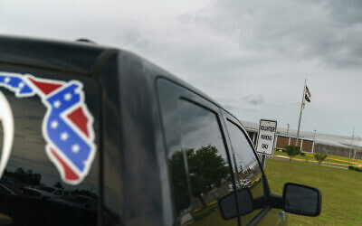 A pickup truck with a Confederate flag-themed decal is parked outside the Reception and Medical Center, the state's prison hospital where new inmates are processed, in Lake Butler, Florida, on April 16, 2021. (AP Photo/David Goldman, File)