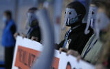 Protestors wear masks during a small demonstration inside the venue of the COP26 U.N. Climate Summit in Glasgow, Scotland, Friday, Nov. 12, 2021. (AP Photo/Alastair Grant)