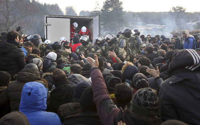 Belarusian servicemen control the situation while migrants get humanitarian aid as they gather at the Belarus-Poland border near Grodno, Belarus, Nov. 12, 2021 (Ramil Nasibulin/BelTA pool photo via AP) Belarusian servicemen control the situation while migrants get humanitarian aid as they gather at the Belarus-Poland border near Grodno, Belarus, Nov. 12, 2021 (Ramil Nasibulin/BelTA pool photo via AP)