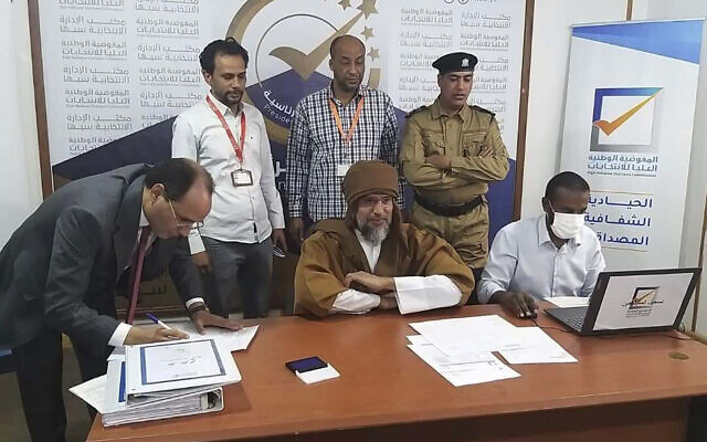Seif al-Islam, center, the son and one-time heir apparent of late Libyan dictator Muammar Gaddafi, registers his candidacy for the country’s presidential elections, in Sabha, Libya, November 14, 2021. (Libyan High National Elections Commission via AP) Seif al-Islam, center, the son and one-time heir apparent of late Libyan dictator Muammar Gaddafi, registers his candidacy for the country’s presidential elections, in Sabha, Libya, November 14, 2021. (Libyan High National Elections Commission via AP)
