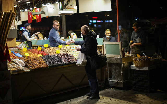 A man pays for his food at the Egyptian bazaar in Istanbul, Turkey, Thursday, Nov. 18, 2021. (AP Photo/Francisco Seco) A man pays for his food at the Egyptian bazaar in Istanbul, Turkey, Thursday, Nov. 18, 2021. (AP Photo/Francisco Seco)