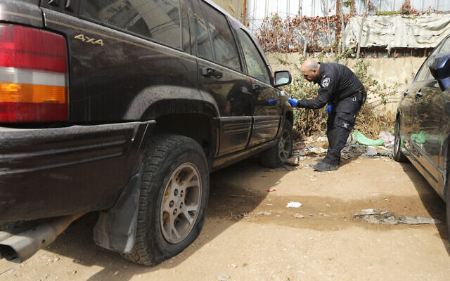 An Israeli police officer collects evidence from a vandalized vehicle in the Sheikh Jarrah neighborhood of East Jerusalem, November 19, 2021. (AP Photo/Mahmoud Illean) An Israeli police officer collects evidence from a vandalized vehicle in the Sheikh Jarrah neighborhood of East Jerusalem, November 19, 2021. (AP Photo/Mahmoud Illean)