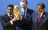 Mohamed bin Hamad Al-Thani, left, Chairman of the 2022 bid committee, and Sheikh Hamad bin Khalifa Al-Thani, Emir of Qatar, hold the World Cup trophy in front of FIFA Secretary General Jerome Valcke after the announcement that Qatar will host the 2022 soccer World Cup, made in Zurich, Switzerland, on Dec. 2, 2010. (Anja Niedringhaus/AP)