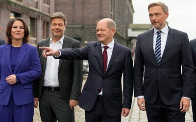 Social Democratic Party chancellor candidate Olaf Scholz (second right) stands with the Green party leaders Annalena Baerbock (left) and Robert Habeck (second left) and the Free Democratic Party chairman Christian Lindner (right), as they arrive for a joint news conference in Berlin, Germany, on November 24, 2021. (AP Photo/Markus Schreiber) Social Democratic Party chancellor candidate Olaf Scholz (second right) stands with the Green party leaders Annalena Baerbock (left) and Robert Habeck (second left) and the Free Democratic Party chairman Christian Lindner (right), as they arrive for a joint news conference in Berlin, Germany, on November 24, 2021. (AP Photo/Markus Schreiber)