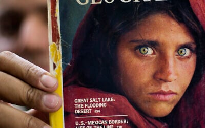 In this file photo, taken on October 26, 2016, Pakistan's Inam Khan, owner of a book shop shows a copy of a magazine with the photograph of Afghan refugee woman Sharbat Gulla, from his rare collection in Islamabad, Pakistan. (AP Photo/B.K. Bangash, File) In this file photo, taken on October 26, 2016, Pakistan's Inam Khan, owner of a book shop shows a copy of a magazine with the photograph of Afghan refugee woman Sharbat Gulla, from his rare collection in Islamabad, Pakistan. (AP Photo/B.K. Bangash, File)