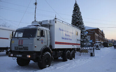 A Russian Emergency Ministry truck is parked at the Listvyazhnaya mine, right, near Belovo, in the Kemerovo region of southwestern Siberia, Russia, November 26, 2021. (AP Photo/Sergei Gavrilenko)