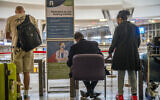 People line up to get tested for COVID at OR Tambo's airport in Johannesburg, South Africa, Friday Nov. 26, 2021. (AP Photo/Jerome Delay)