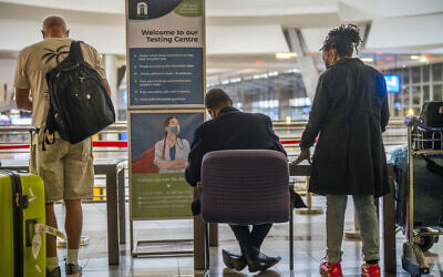 People line up to get tested for COVID at OR Tambo's airport in Johannesburg, South Africa, Friday Nov. 26, 2021. (AP Photo/Jerome Delay)